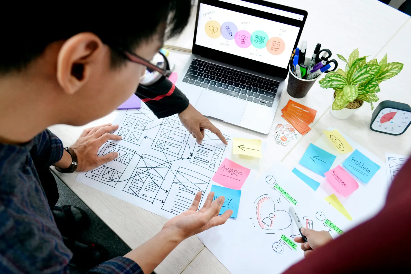 A designer sketching wireframes with sticky notes